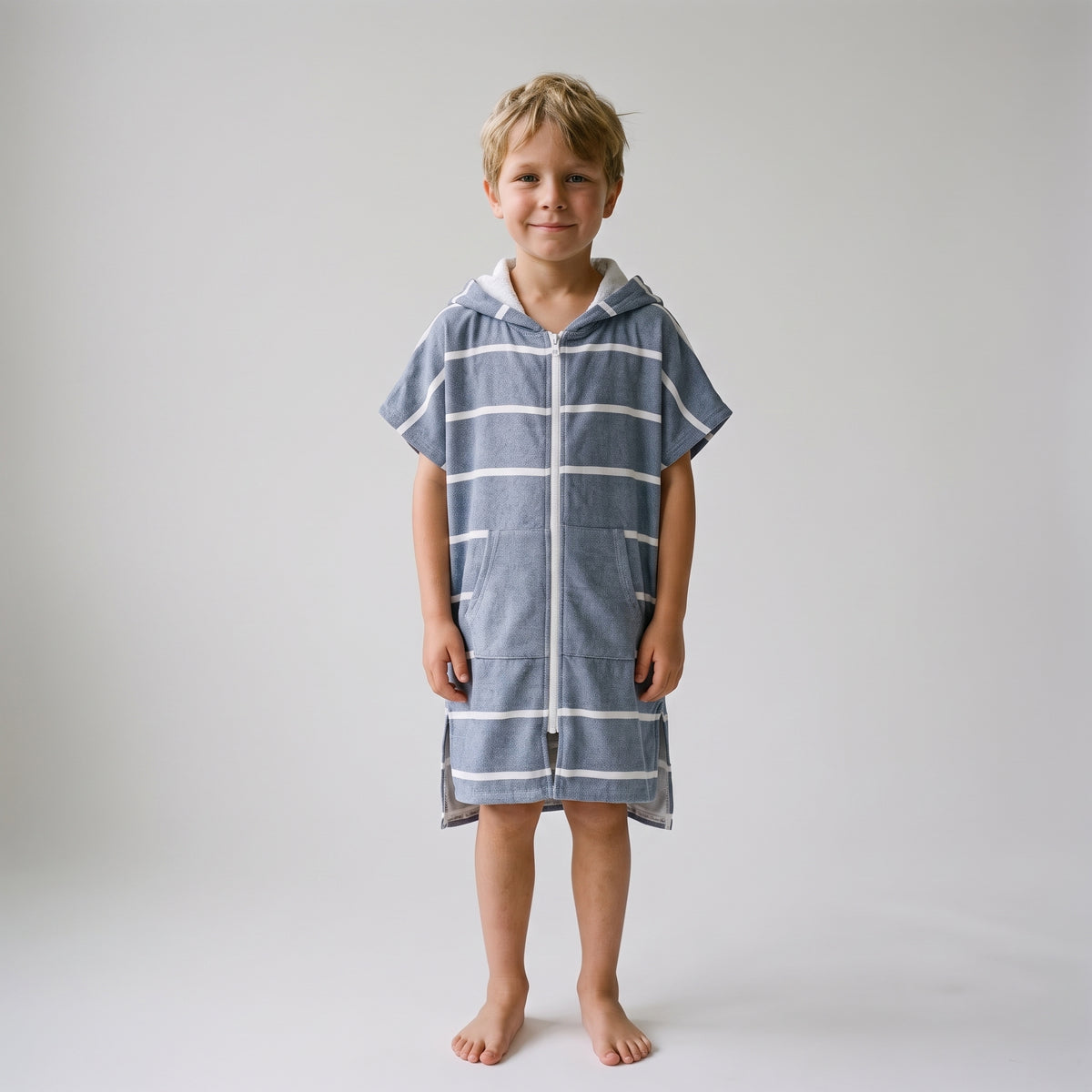Amalfi kids hooded towel in navy and white stripes worn by a young boy, studio photo, front view