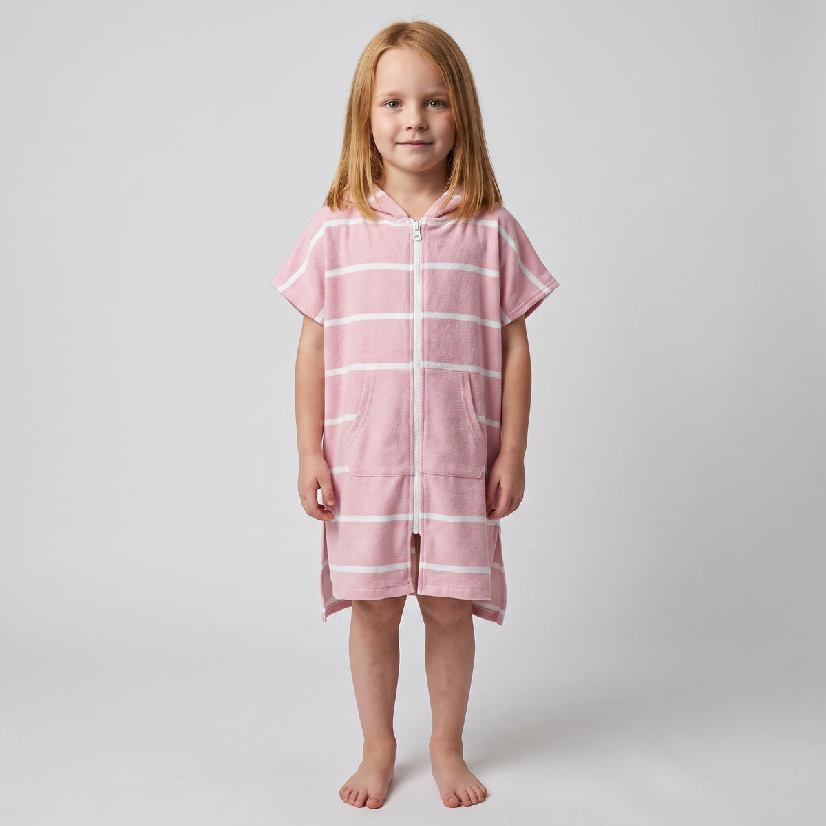 Amalfi kids hooded towel in pink and white stripes worn by a young girl, studio photo, front view