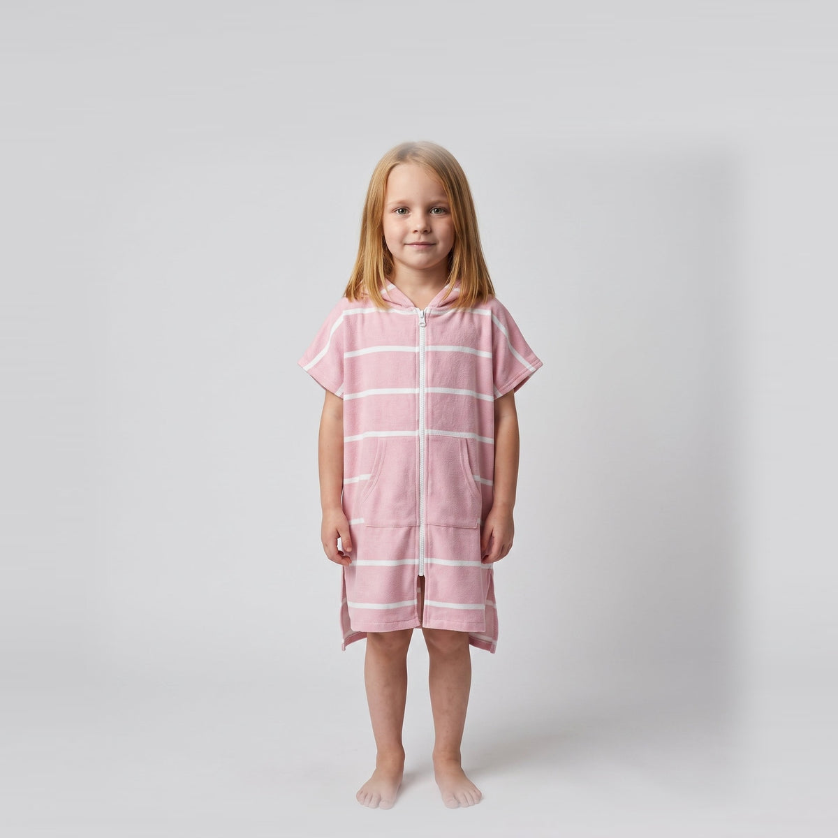 Amalfi kids hooded towel in pink and white stripes worn by a young girl, studio photo, front view