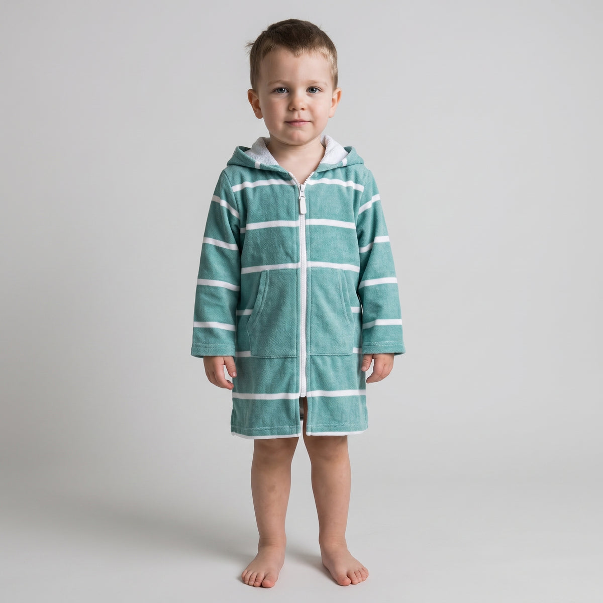 Long sleeve Amalfi toddler hooded towel in teal and white stripes worn by a toddler boy, studio front view