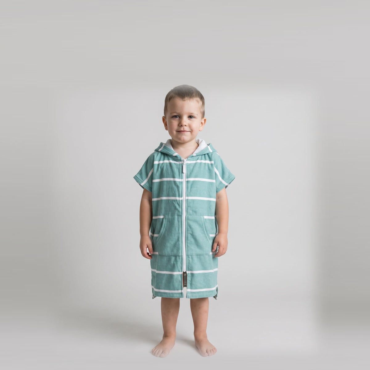 Amalfi toddler hooded towel in teal and white stripes worn by a toddler boy, studio photo, front view