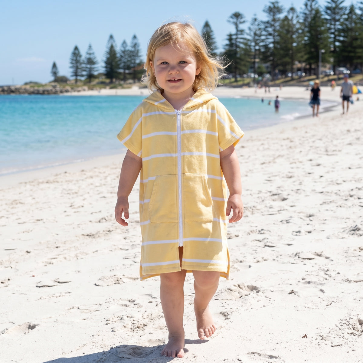 Toddler girl in the Amalfi yellow and white toddler zip hooded towel, on Cottesloe Beach, Perth