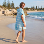 Man wearing the Amalfi Aqua White Turkish hooded towel while walking along a Western Australian beach