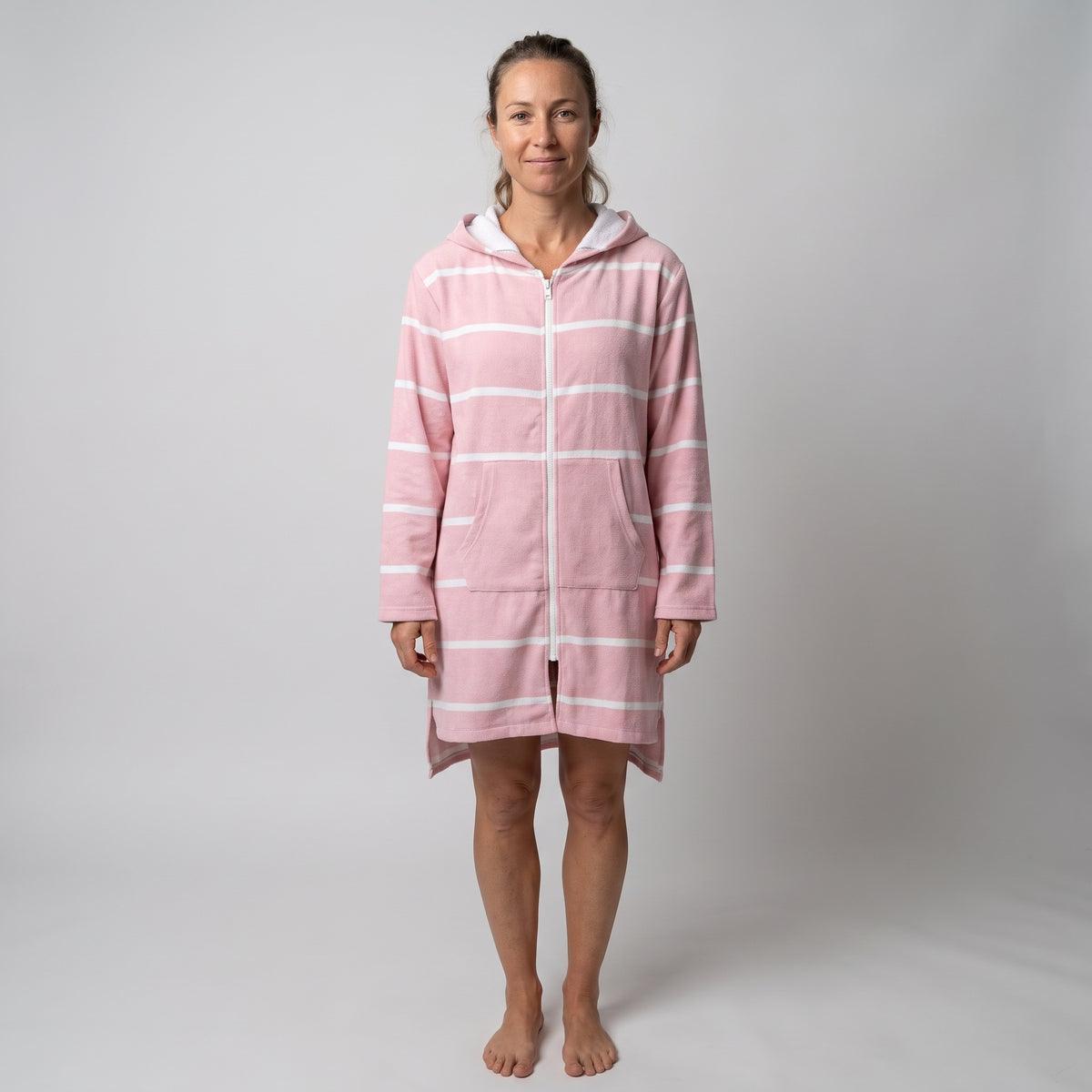Woman wearing the long sleeve Amalfi pink and white striped adult hooded towel, studio front view