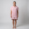 Woman wearing the Amalfi Pink White Turkish hooded towel, front view on a plain studio background