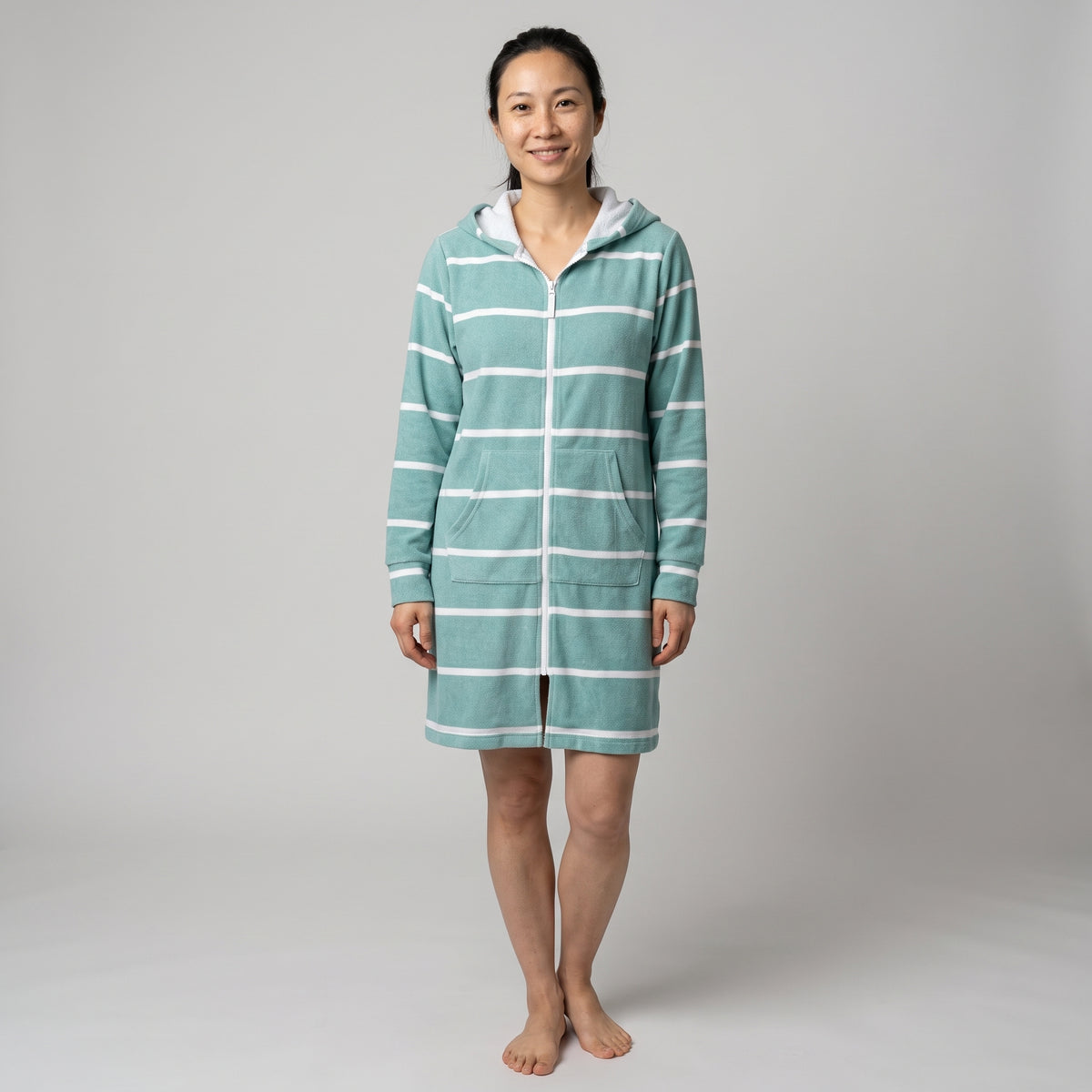 Woman in the long sleeve Amalfi teal and white striped adult hooded towel, studio front view