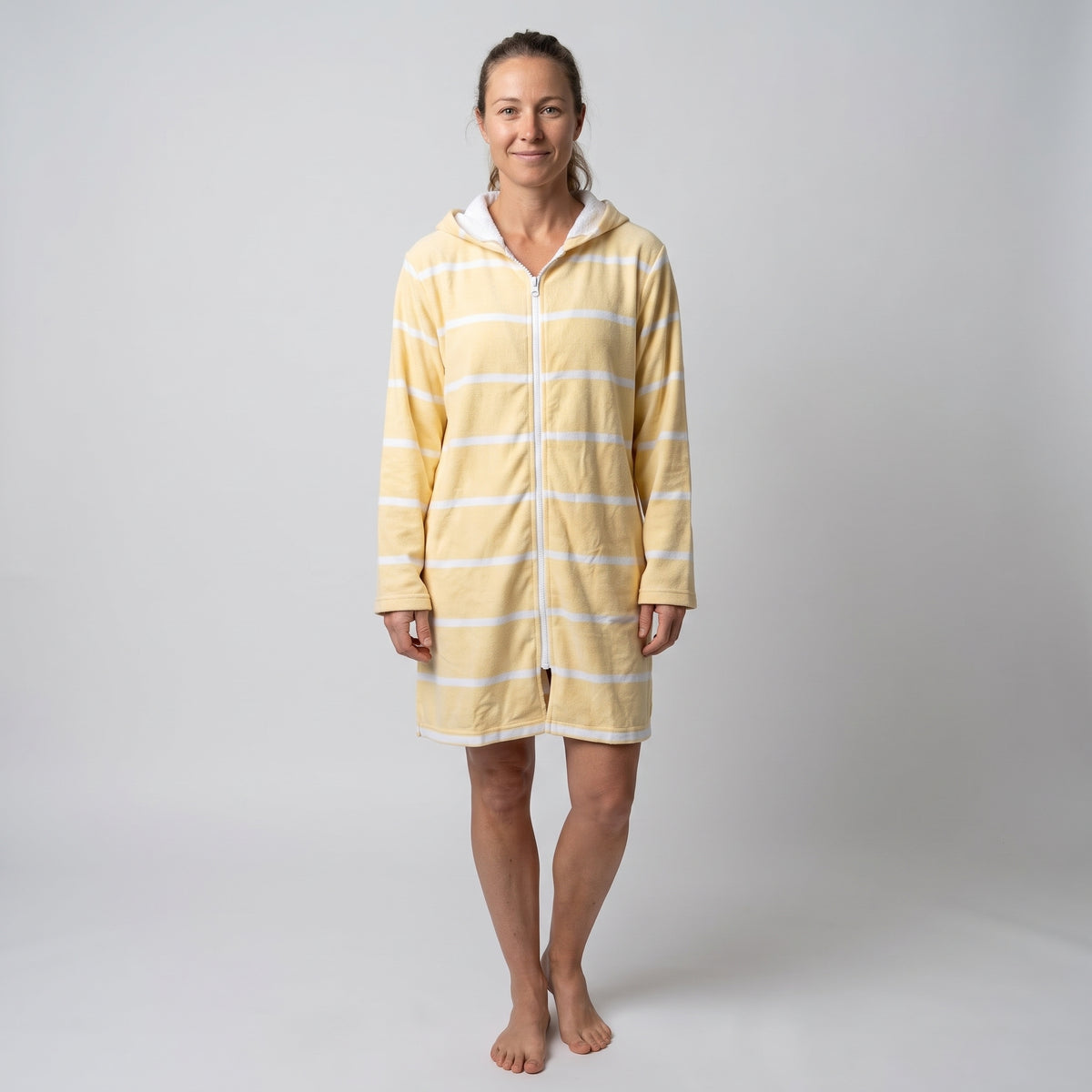 Woman wearing the long sleeve Amalfi yellow and white striped adult hooded towel, studio front view