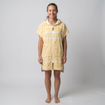 Woman wearing the Amalfi Yellow White Turkish hooded towel, front view on a plain studio background