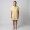 Woman wearing the Amalfi Yellow White Turkish hooded towel, front view on a plain studio background