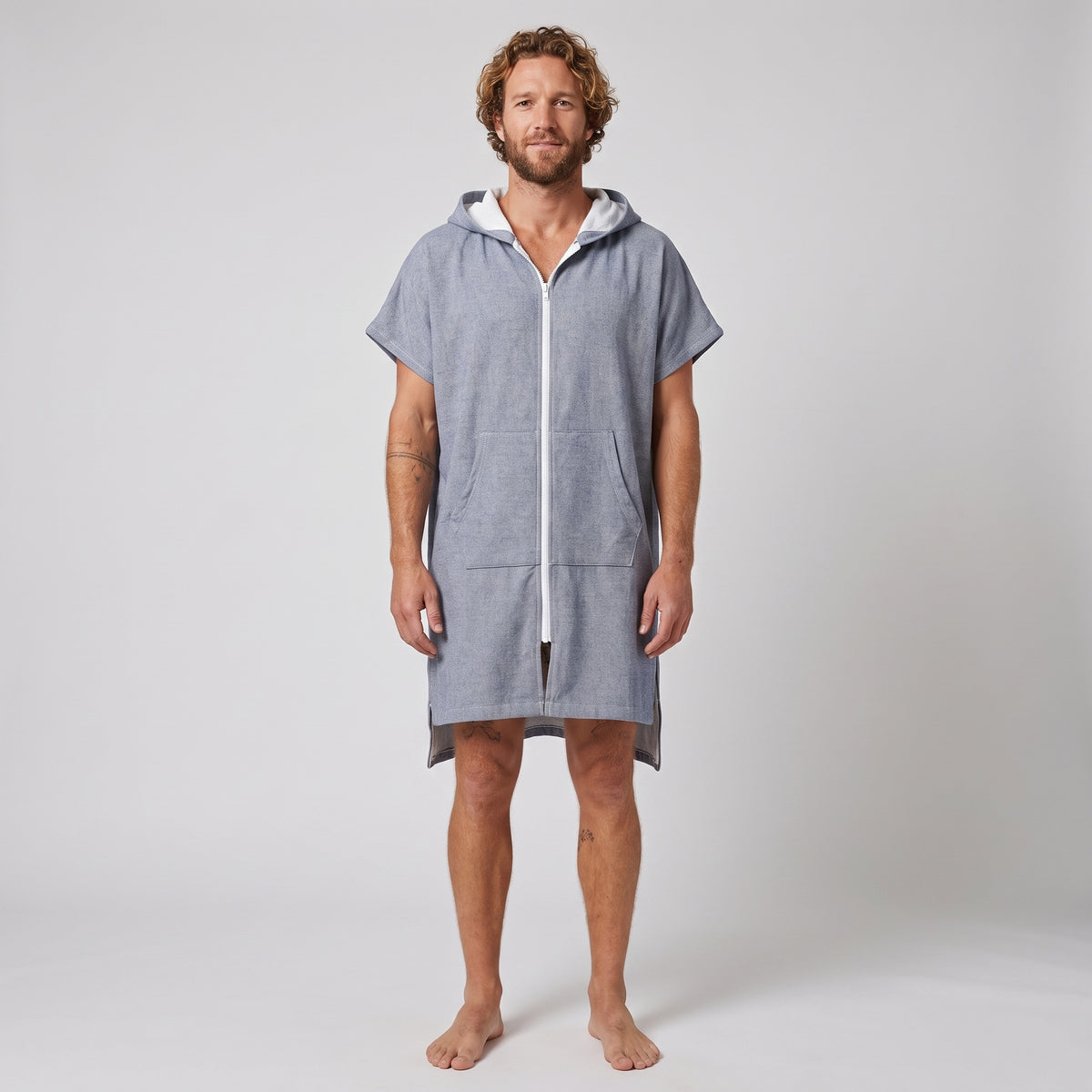 Man wearing the Santorini Navy Turkish hooded towel, front view on a plain studio background