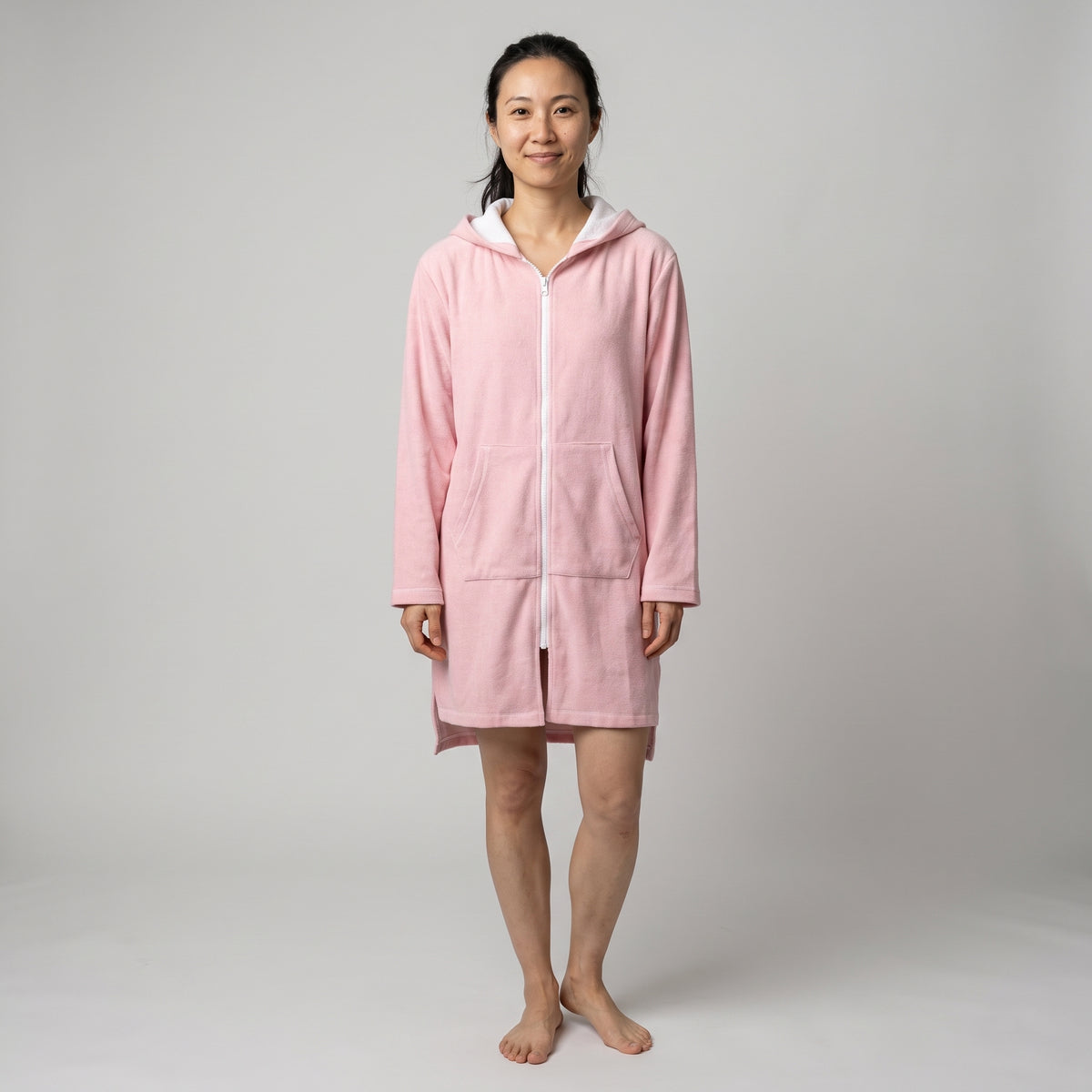 Woman in the long sleeve Santorini solid pink adult hooded towel, studio front view