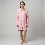 Woman in the long sleeve Santorini solid pink adult hooded towel, studio front view