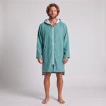 Man wearing the long sleeve Santorini solid teal adult hooded towel, studio front view