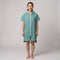 Woman wearing the Santorini Teal hooded towel, front view on a plain studio background
