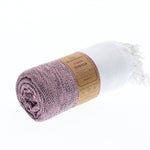 Madrid Turkish towel in mauve rolled and banded with the Moonessa label, ready to pack
