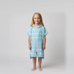 Young girl wearing Amalfi aqua and white striped kids hooded towel, studio photo, front view