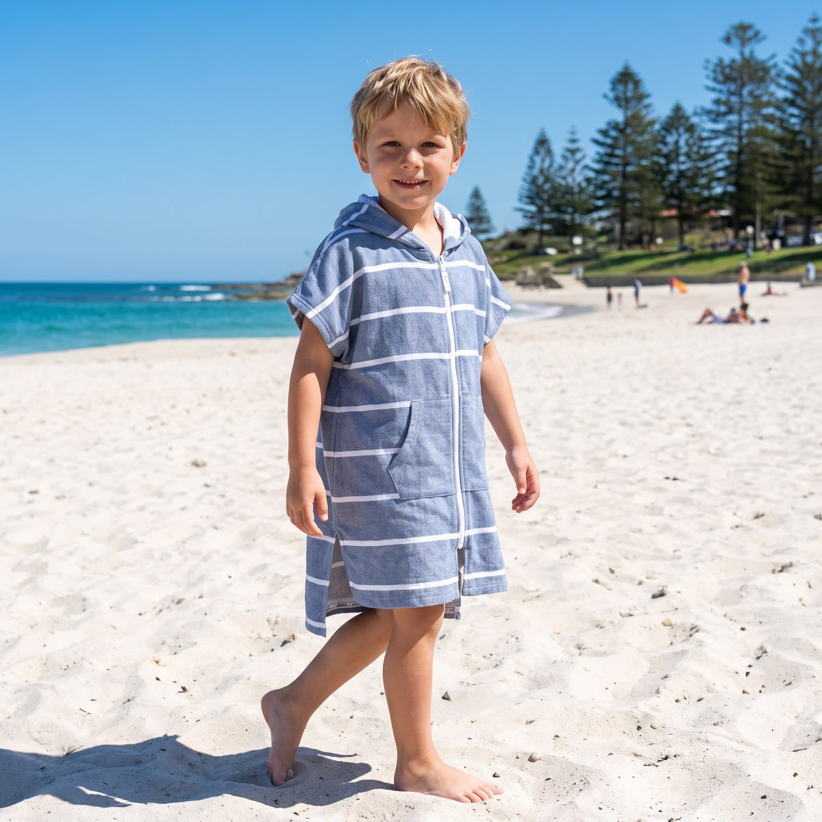 Young boy wearing Amalfi navy and white striped kids hooded towel, on Cottesloe Beach, Perth