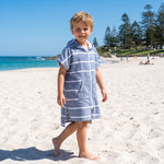 Young boy wearing Amalfi navy and white striped kids hooded towel, on Cottesloe Beach, Perth