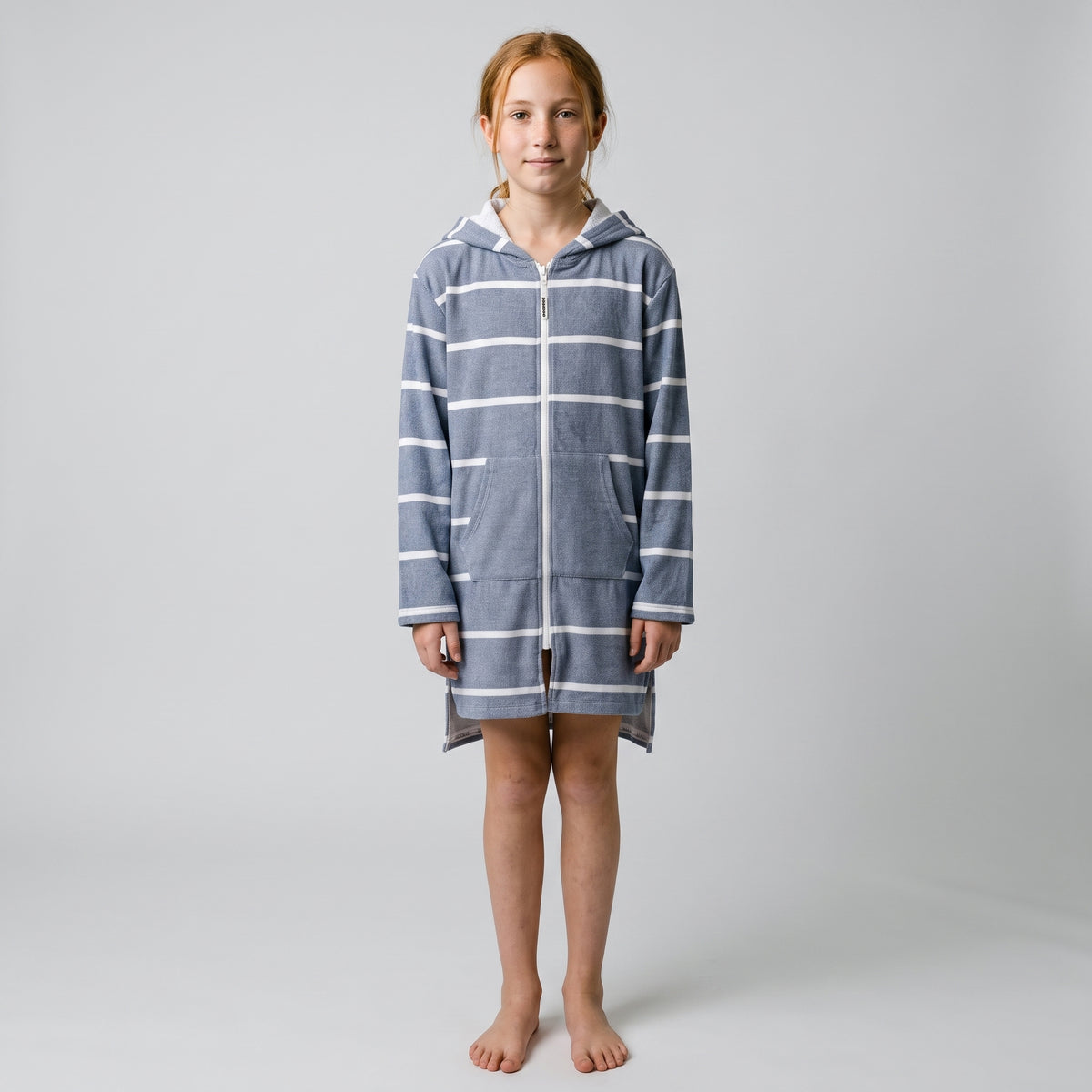 Girl wearing the long sleeve Amalfi navy and white striped kids hooded towel, studio front view
