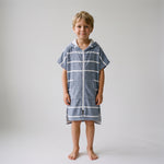 Amalfi kids hooded towel in navy and white stripes worn by a young boy, studio photo, front view