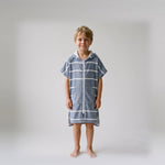 Amalfi kids hooded towel in navy and white stripes worn by a young boy, studio photo, front view