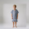 Amalfi kids hooded towel in navy and white stripes worn by a young boy, studio photo, front view