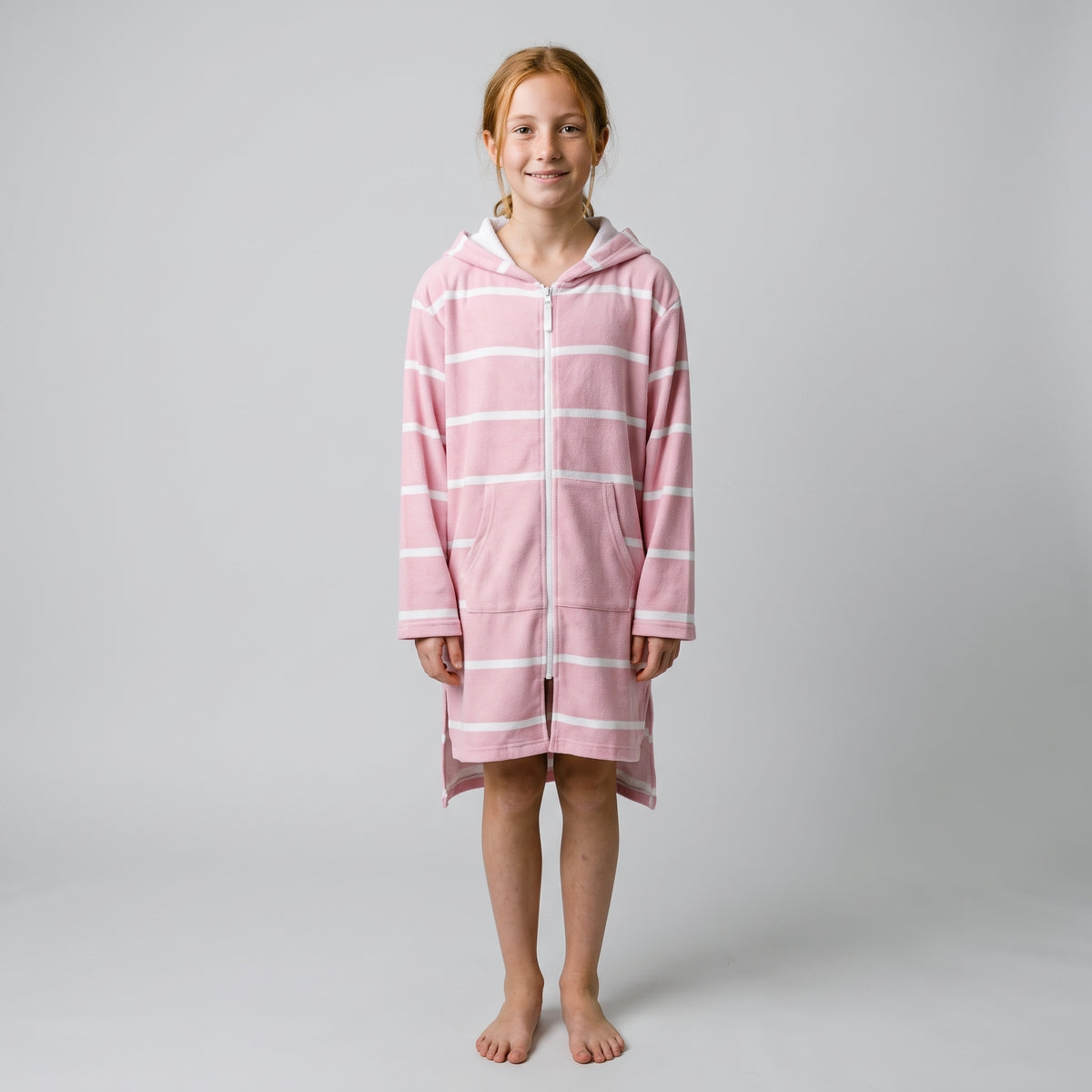 Long sleeve Amalfi kids hooded towel in pink and white stripes worn by a girl, studio front view