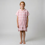 Girl in the Amalfi pink and white kids zip hooded towel, studio photo, front view