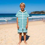 Boy in the Amalfi teal and white kids zip hooded towel, on Bondi Beach, Sydney