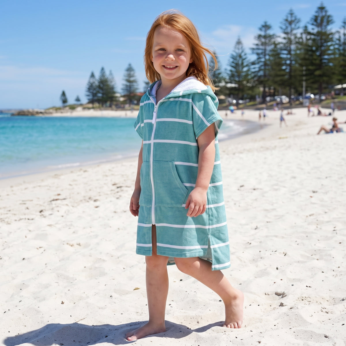 Young girl in the Amalfi teal and white kids zip hooded towel, on Cottesloe Beach, Perth