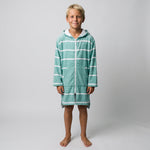Boy wearing the long sleeve Amalfi teal and white striped kids hooded towel, studio front view