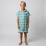 Amalfi kids hooded towel in teal and white stripes worn by a boy, studio photo, front view