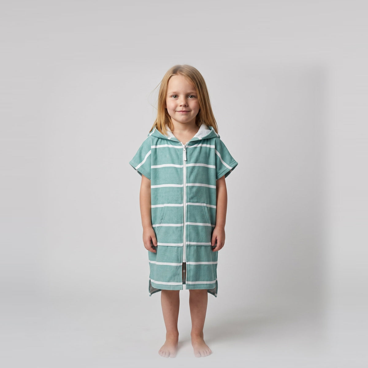 Young girl wearing Amalfi teal and white striped kids hooded towel, studio photo, front view