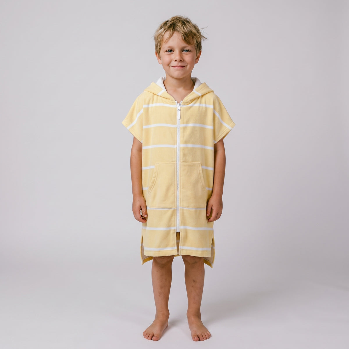 Young boy wearing Amalfi yellow and white striped kids hooded towel, studio photo, front view