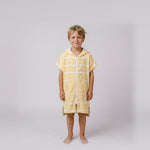 Young boy wearing Amalfi yellow and white striped kids hooded towel, studio photo, front view