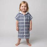 Amalfi toddler hooded towel in navy and white stripes worn by a toddler girl, studio photo, front view