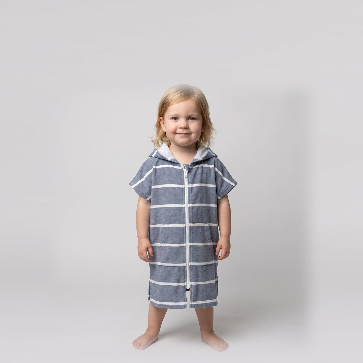 Amalfi toddler hooded towel in navy and white stripes worn by a toddler girl, studio photo, front view