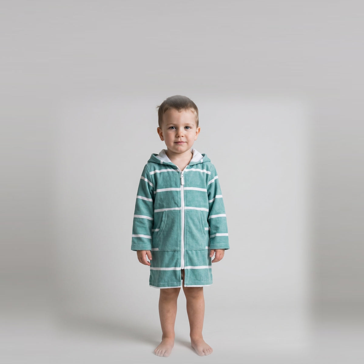 Long sleeve Amalfi toddler hooded towel in teal and white stripes worn by a toddler boy, studio front view