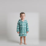 Long sleeve Amalfi toddler hooded towel in teal and white stripes worn by a toddler boy, studio front view