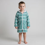 Long sleeve Amalfi toddler hooded towel in teal and white stripes worn by a toddler boy, studio front view