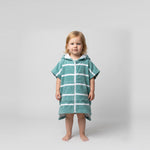 Toddler girl wearing Amalfi teal and white striped toddler hooded towel, studio photo, front view