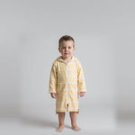Toddler boy wearing the long sleeve Amalfi yellow and white toddler hooded towel, studio front view