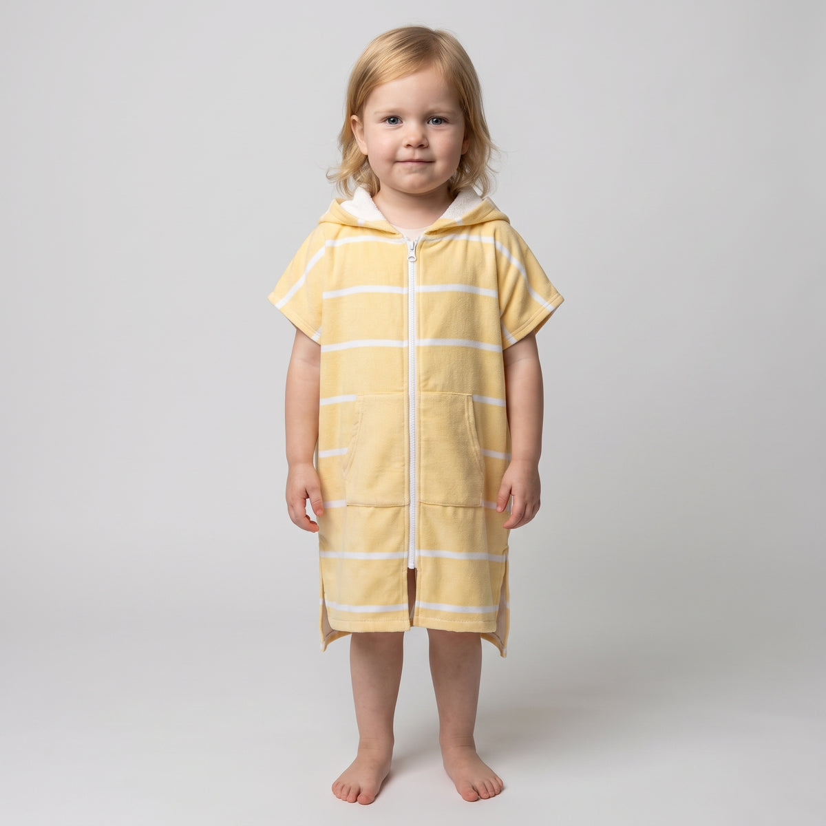 Amalfi toddler hooded towel in yellow and white stripes worn by a toddler girl, studio photo, front view
