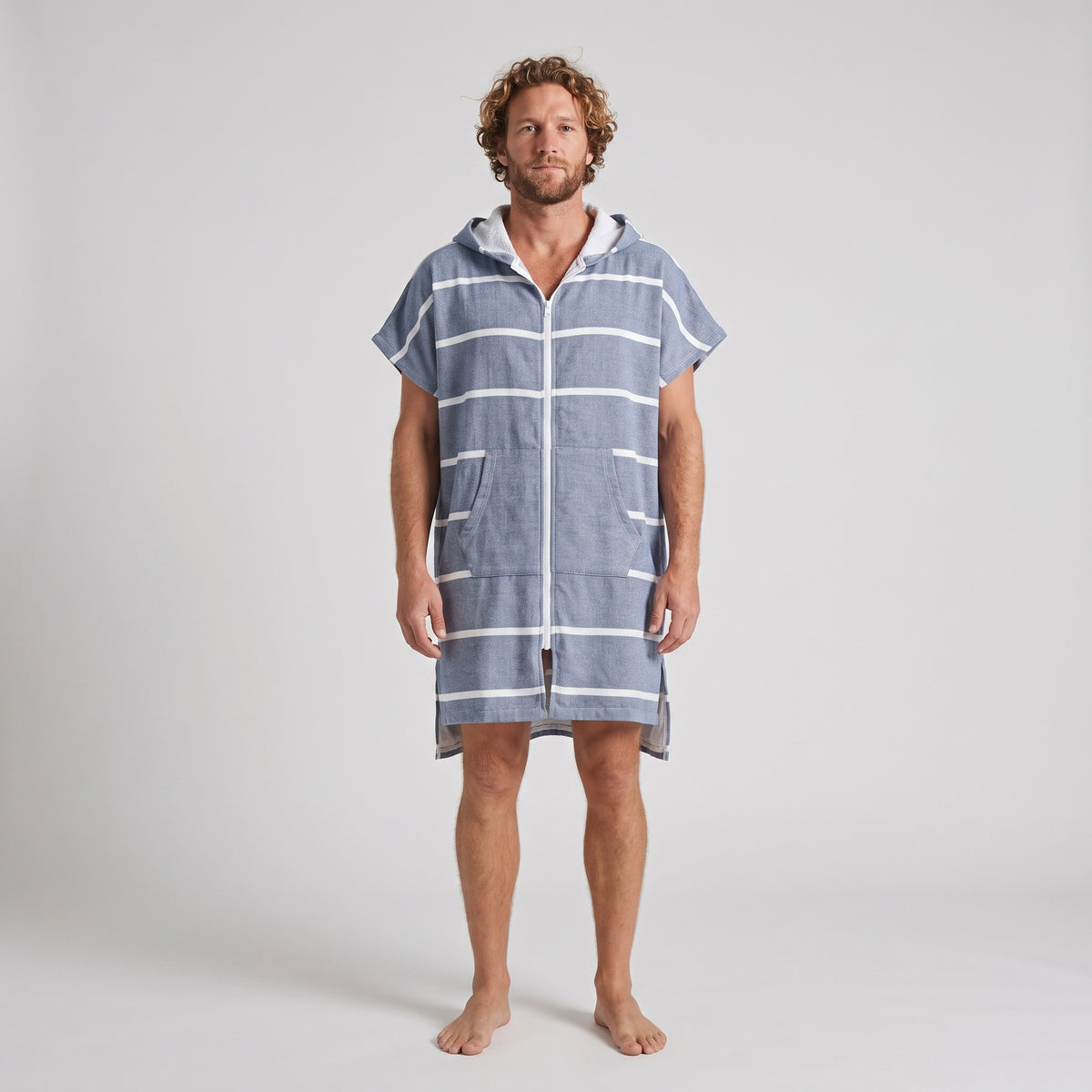 Man wearing the Amalfi Navy White Turkish hooded towel, front view on a plain studio background
