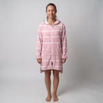 Woman wearing the long sleeve Amalfi pink and white striped adult hooded towel, studio front view