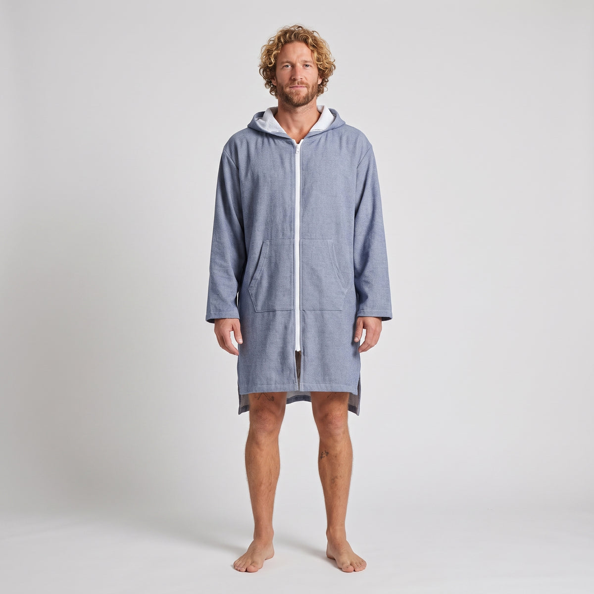 Man wearing the long sleeve Santorini solid navy adult hooded towel, studio front view
