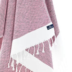 Close-up of the Madrid Turkish towel's mauve diamond weave with hand-twisted tassels